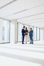 Full length of business people having discussion in empty office Royalty Free Stock Photo