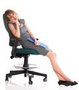 Full length business woman sitting on chair holding clipboard is Royalty Free Stock Photo