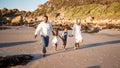 Full length of a carefree young african american family with two children holding hands and having fun while running on Royalty Free Stock Photo