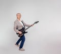 Full length of cheerful senior businesswoman singing and playing electric guitar on white background Royalty Free Stock Photo