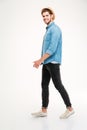 Full length of cheerful young man walking and smiling Royalty Free Stock Photo