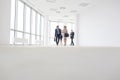 Full length of colleagues talking while walking in corridor at office Royalty Free Stock Photo