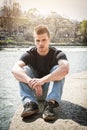 Contemplative young man sitting beside river in Turin Royalty Free Stock Photo