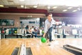 Dedicated Teen Playing Bowling With Green Ball In Club Royalty Free Stock Photo