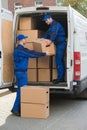 Delivery Men Unloading Cardboard Boxes From Truck Royalty Free Stock Photo