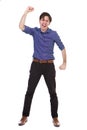 Full length ecstatic young man standing with fist raised