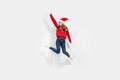 Full length of excited young woman wearing a red Santa Claus hat and a medical protective mask on her face, having fun and jumping Royalty Free Stock Photo