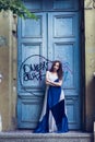 Full length fashion portrait modern woman standing near old door Royalty Free Stock Photo