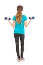 Full length fitness woman rearview lifting dumbbells