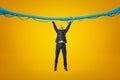 Full length front view of businessman hanging gripping at blue sticky slime thread on amber background.