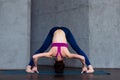 Full-length front view of sporty young woman practicing yoga doing standing straddle forward bend pose, Prasarita Royalty Free Stock Photo