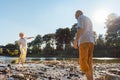 Funny senior couple playing with water at the river in a sunny day