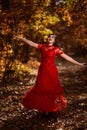 Woman in red dress dancing in the oak forest, full body Royalty Free Stock Photo