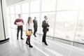 Full length of group of happy young business people walking the corridor in office together. Walk team. Royalty Free Stock Photo