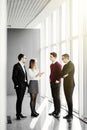 Full length of group of happy young business people walking the hall in office together Royalty Free Stock Photo