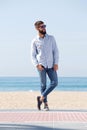 Full length handsome man in sunglasses standing on beach Royalty Free Stock Photo