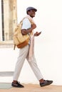 Full length handsome young guy walking with bag and phone Royalty Free Stock Photo