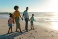 Full length of happy african american family enjoying summer holiday together at beach Royalty Free Stock Photo