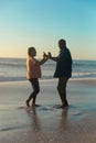 Full length of happy african american senior couple dancing at beach against sky with copy space Royalty Free Stock Photo