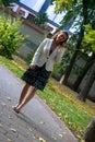 Businesswoman talking on cell phone while walking in the park. Royalty Free Stock Photo