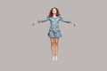 Full length happy calm pretty girl in vintage ruffle dress levitating hovering in mid-air with raised hands as wings