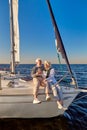 Full length of happy senior family couple drinking wine or champagne while celebrating wedding anniversary on a sailboat Royalty Free Stock Photo