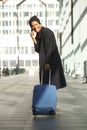 Full length happy travel man with luggage talking on cellphone Royalty Free Stock Photo