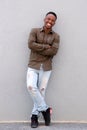 Full length happy young black guy smiling against gray wall Royalty Free Stock Photo