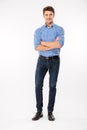 Full length of happy young man standing with arms crossed Royalty Free Stock Photo