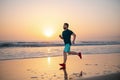 Full length of healthy man running and sprinting outdoors. Male runner. Man running on the beach at sunset. Healthy