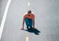 Full length of healthy man running and sprinting outdoors on road. Male runner on start.