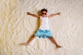 Full length high angle view photo of charming pretty small boy dressed white shirt having fun sand outdoors ocean beach Royalty Free Stock Photo