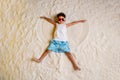 Full length high angle view photo of pretty cool small boy dressed white shirt lying having fun sand outdoors seaside Royalty Free Stock Photo
