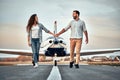 Full-length image of beautiful young stylish couple near private plane