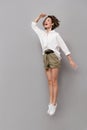 Full length image of caucasian woman 20s smiling and jumping, is Royalty Free Stock Photo