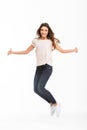 Full length image of Cheerful brunette woman in t-shirt jumping Royalty Free Stock Photo
