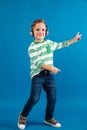 Full length image of cheerful young boy listening music Royalty Free Stock Photo