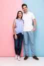 Full length image of european man and woman in casual wear hugging and smiling together, isolated over colorful background Royalty Free Stock Photo