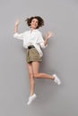 Full length image of european woman 20s smiling and jumping, iso Royalty Free Stock Photo