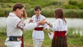 Full length image of a family with kids in traditional romanian clothes, dancing outside. Royalty Free Stock Photo