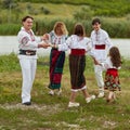 Full length image of a family with kids in traditional romanian clothes, dancing outside. Royalty Free Stock Photo