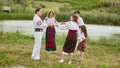 Full length image of a family with kids in traditional romanian dress in a park. Family dancing outside. Royalty Free Stock Photo