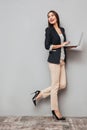 Full length image of Happy business woman holding laptop computer Royalty Free Stock Photo