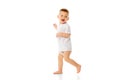 Full-length image of little happy baby boy, child standing in t-shirt and diaper, playing, walking isolated over white Royalty Free Stock Photo