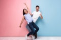 Full length image of optimistic man and woman in casual wear laughing and having fun together, isolated over colorful background Royalty Free Stock Photo