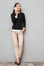 Full length image of Smiling asian woman in business clothes