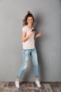 Full length image of Smiling woman in t-shirt listening music Royalty Free Stock Photo