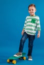 Full length image of smiling young boy posing with skateboard Royalty Free Stock Photo