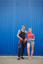 Young modern stylish hipsters couple on blue background, sunny portrait couple teenagers. Royalty Free Stock Photo