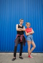 Young modern stylish hipsters couple on blue background, sunny portrait couple teenagers. Royalty Free Stock Photo